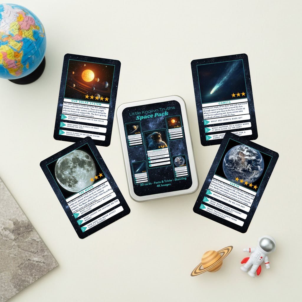 Space-themed trading cards on a white surface with a globe and astronaut figurine.